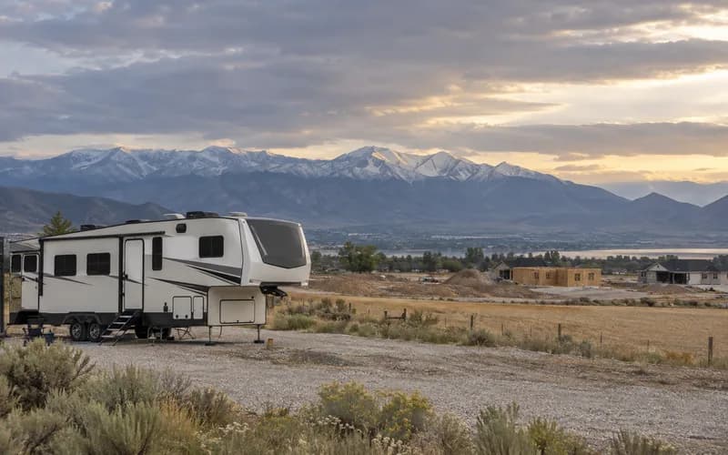 A fifth-wheel parked on gravel at Lehi, where farmland gives way to new construction