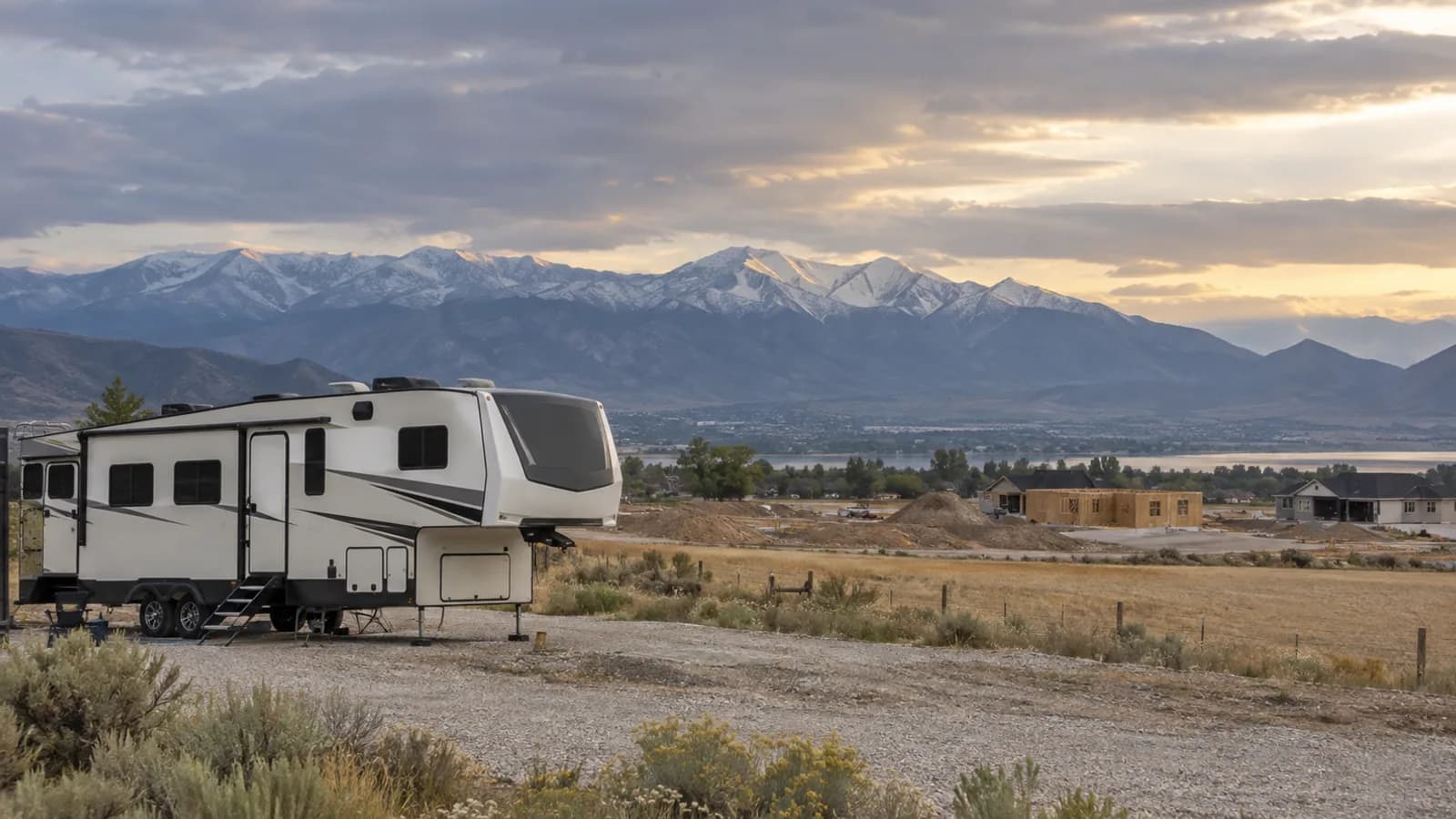 open farmland giving way to new construction, a fifth-wheel parked on gravel